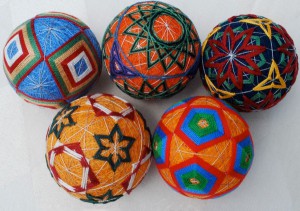 Temari is a traditional Japanese art form that often uses geometrically inspired designs. Yackel's temari balls show spherical versions of geometric shapes based on the five Platonic solids. Artist: Carolyn Yackel.